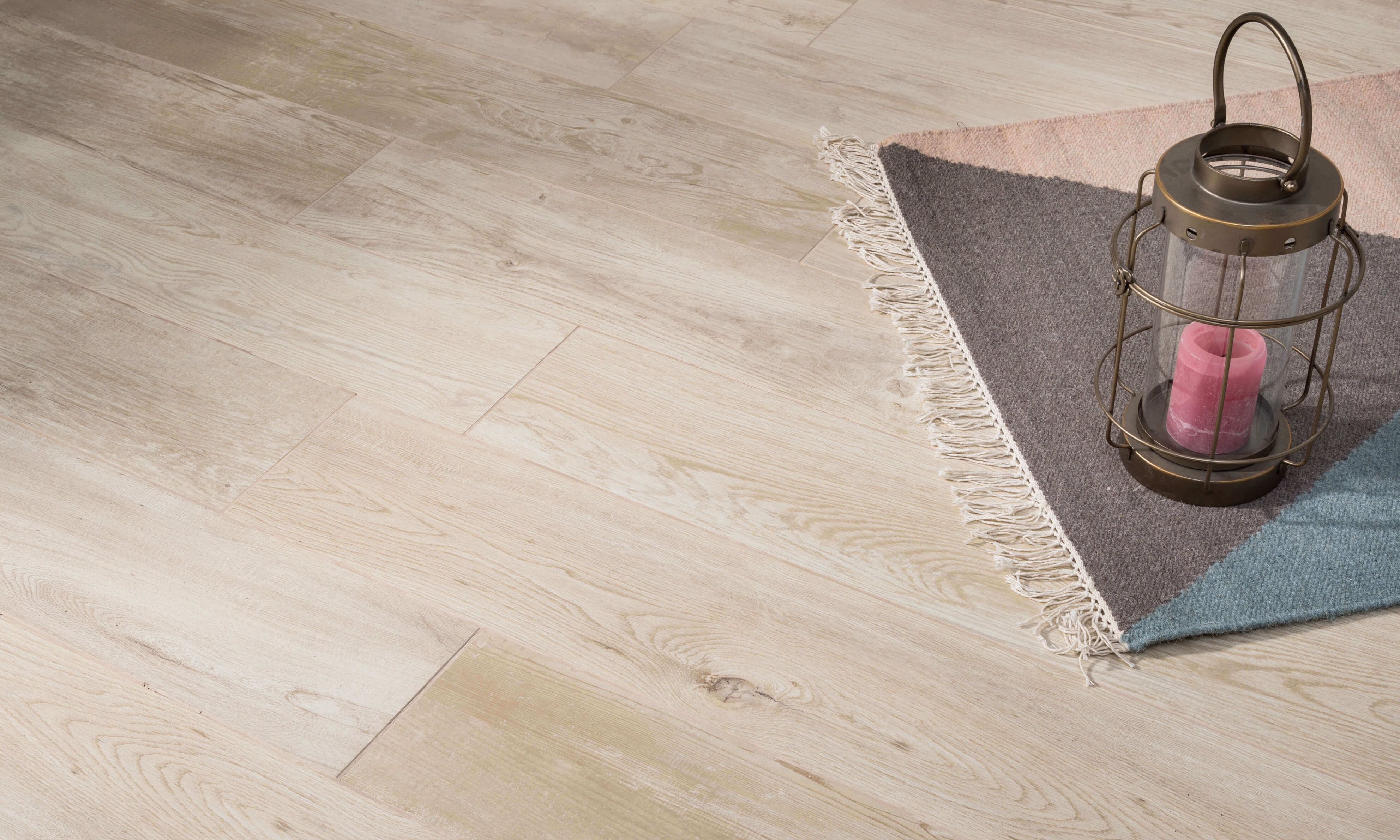 Holzoptikfliesen Urban White in hellen Beigetönen mit Teppich und Dekolaterne