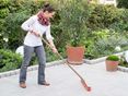 Frau reinigt Granit Mundo Grau-Terrasse