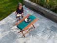 Mit Stil entspannen auf einer Afyon Grey Terrasse! Frau sitzt an Holztisch auf einer Terrasse mit Platten aus Marmor