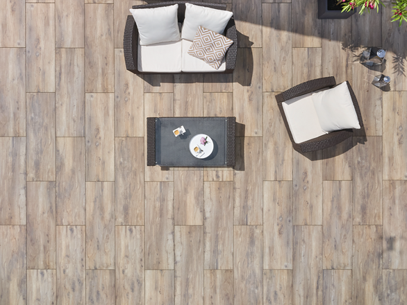 Vogelperspektive auf eine Terrasse mit Platten in Holzoptik und modernen Möbeln