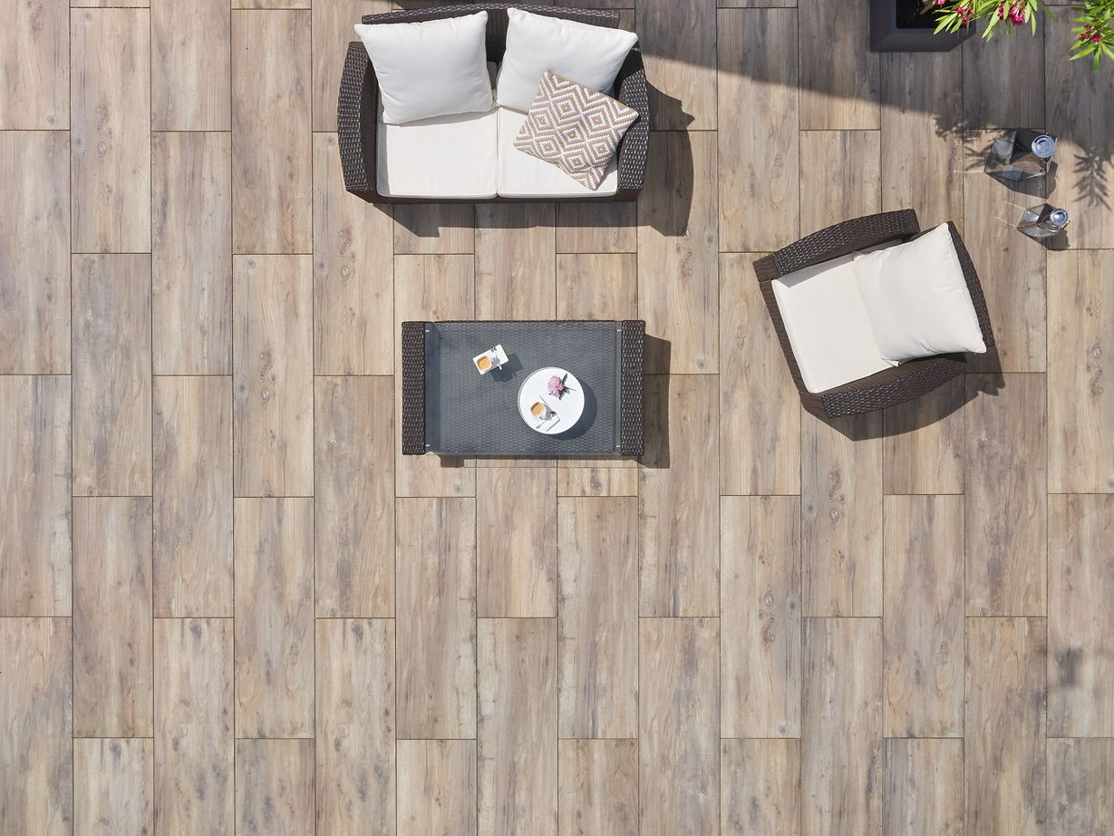 Vogelperspektive auf eine Terrasse mit Platten in Holzoptik und modernen Möbeln