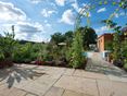Traumhafter Natursteingarten mit Yellow Mint Helle Platten aus Sandstein Yellow Mint mit naturnahem, mediterranem Garten im Hintergrund