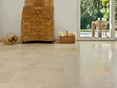 Harmonische Beigetöne: Kalksteinfliese Cleopatra Light (Kundenprojekt) Antiker Holzschrank auf hellen Kalksteinfliesen Cleopatra Light, im Hintergrund Blick auf die Terrasse und den Garten