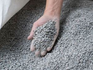 Hand nimmt Edelsplitt aus einem großen Sack