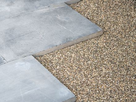 Blau-graue Kalksteinplatten in einem Edelsplittbett